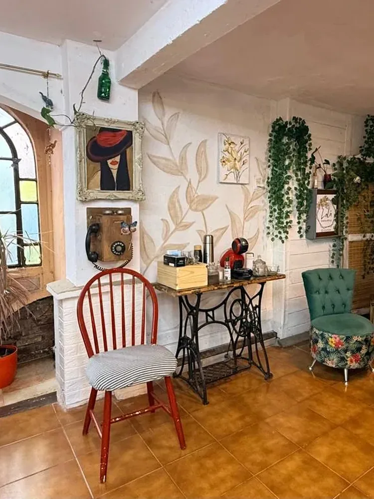 Rincón con silla roja, teléfono antiguo y mural de hojas